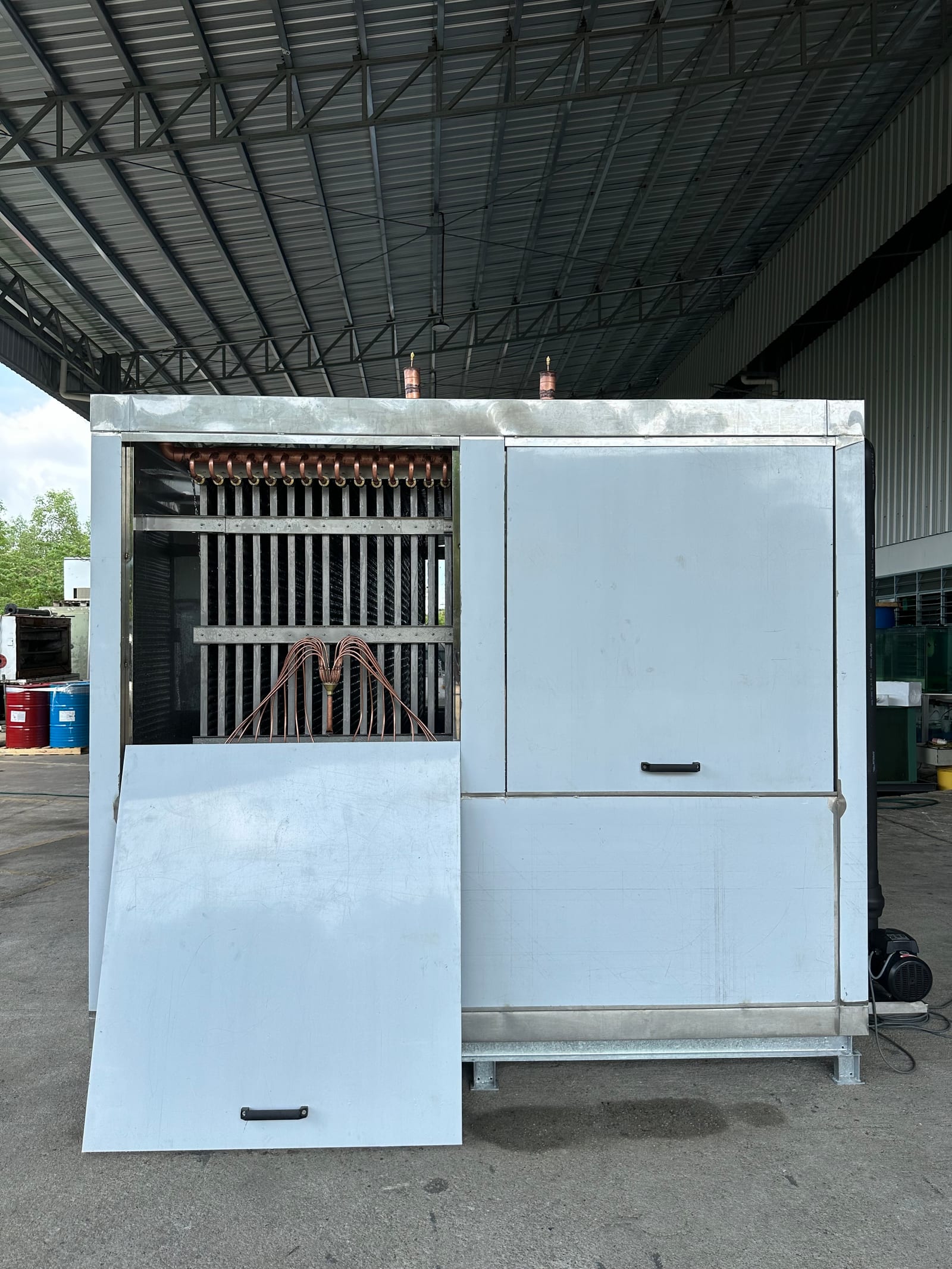Water chiller with service door open, showing the stainless cold plates and copper distribution manifold